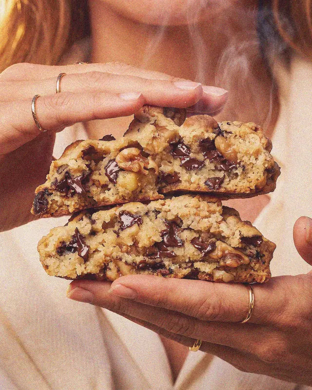 Gros plan sur un cookie maison coupé en deux, chocolat fondant, encore chaud