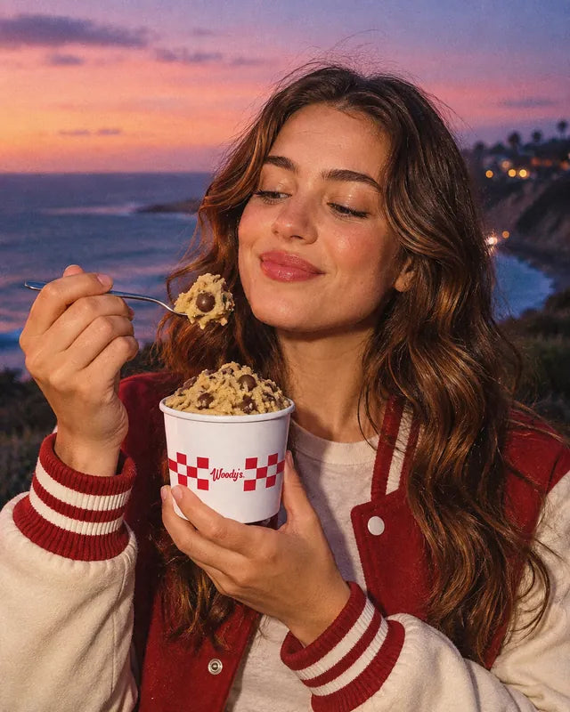 Une étudiante en blouson rouge déguste un cookie dough Woody's Factory à la cuillère