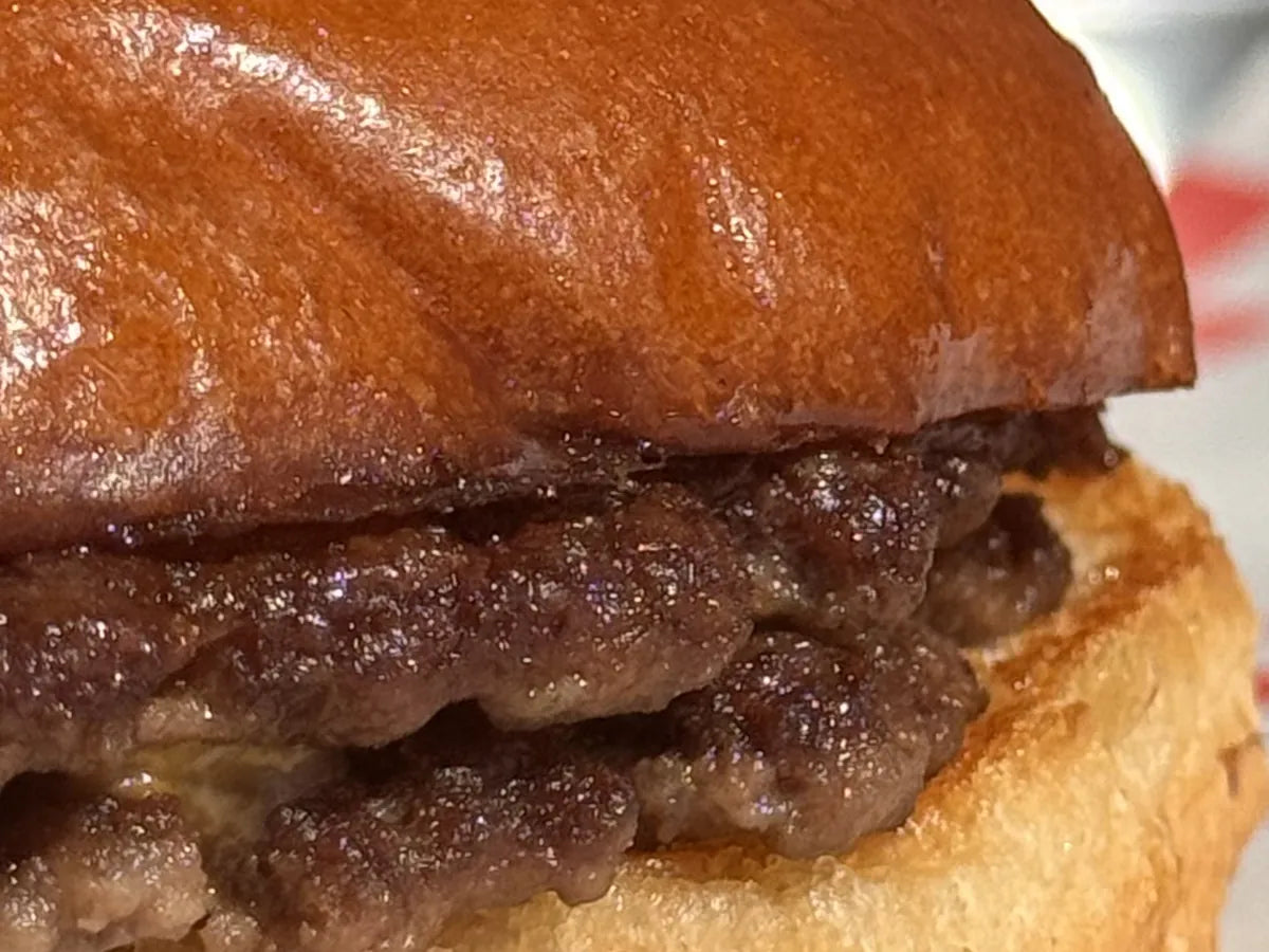 Gros plan sur les steaks smashés de The 1976 : croûte brune et bords croustillants
