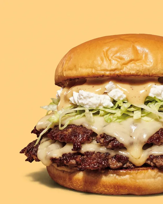 Smash burger The Golden Goat de Woody's Factory : double steak smashé, emmental, chèvre, salade et sauce moutarde-miel